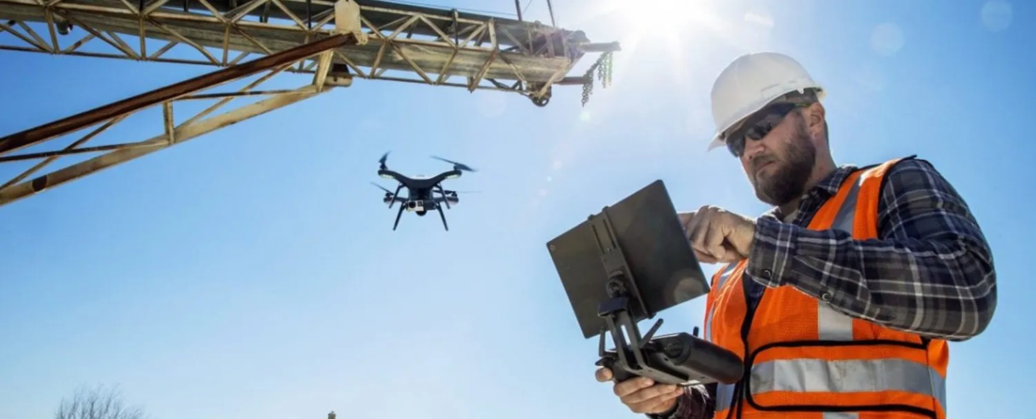 Engenheiro com capacete operando drone em canteiro de obra