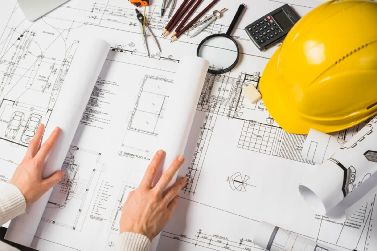 Planta baixa, capacete e instrumentos de desenho técnico — regularização de imóveis em Manaus